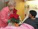woman giving flowers to patient in hospital