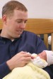 father feeding baby