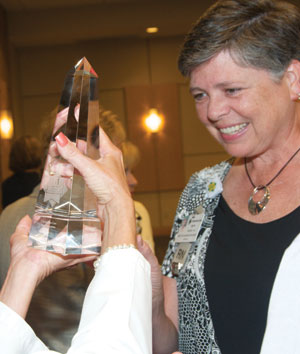 woman looks at glass obelisk trophy