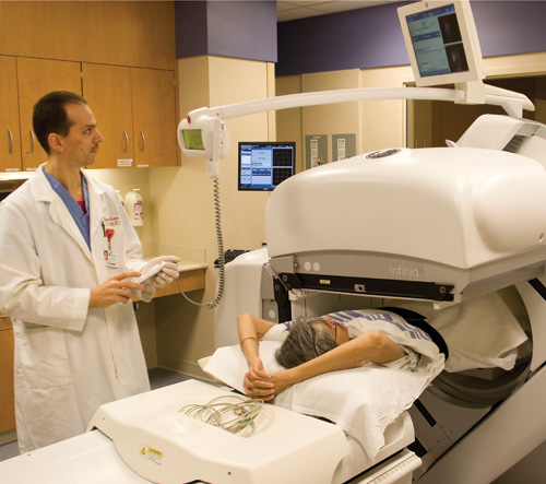 doctor performs nuclear medicine scan on patient