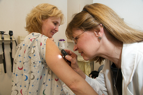 doctor examining a woman during a skin cancer screening