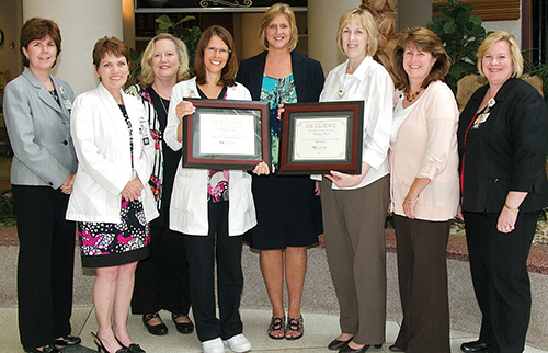 group of nurses and health care leaders posing with award