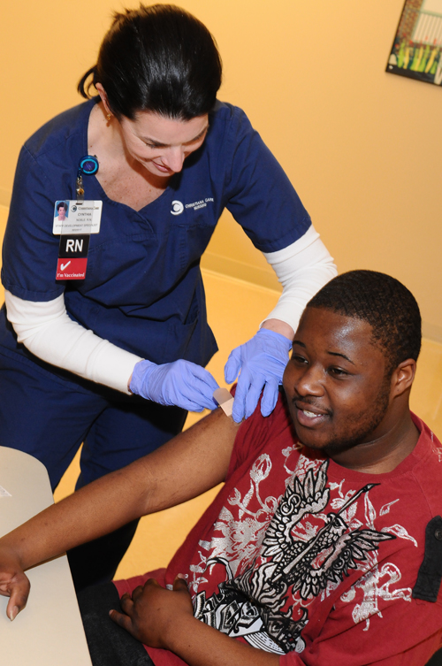 Cynthia Noble, RN, staff development specialist, vaccinates hospital visitor Dorian Cooper at a free flu vaccination station in Wilmington Hospital. The vaccination stations were just one of the ways that Christiana Care stepped up during the height of the flu season.