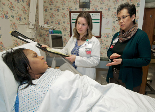 Working with a patient at Christiana Hospital, Angelica Reyes-Hull interprets Spanish to English for Jennifer Painter, RN.