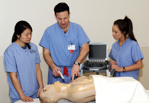 Joseph Bennett, M.D., demonstrates a procedure with University of Delaware students Anna Sung and Madison DeFrank in the Virtual Education and Simulation Training Center at Christiana Care's Newark campus.