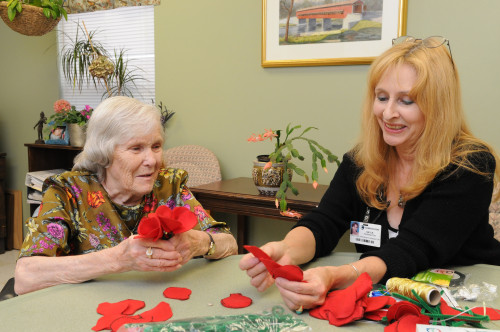 Adult Day Program Director Gayle Pennington, MS, MA, NCC, enjoys an art project with a client.