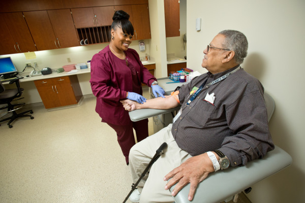 Phlebotomist Shakeena Wilson prepares Thomas Bratton to have his blood drawn at the lab service established just for patients of the new HealthCare Center at Medical Arts Pavilion 2. 
