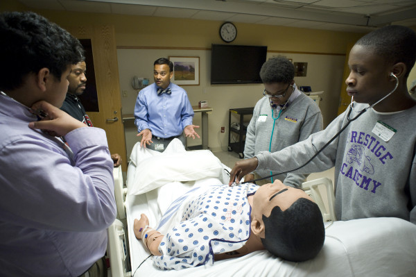 Vinay Maheshwari, M.D., director of medical critical care at Christiana Care, uses a robotic mannequin in Christiana Care's Virtual Education and Simulation Training Center to teach students of Prestige Academy Charter School about how to asses a patient's vital signs.