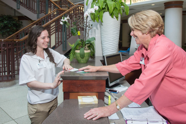 Volunteen Ashley Cooke and Mary Julian of the Junior Board help to create a great first impression as they welcome visitors at the Christiana Hospital lobby.