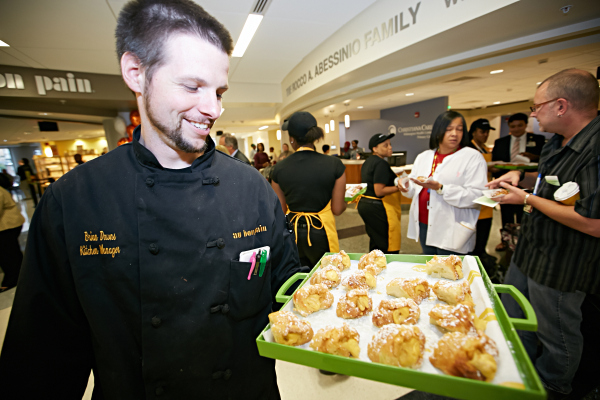 Au Bon Pain Kitchen Manager Brian Downs tempts hospital staff with a platter of pastries at the Blue Granite Cafe grand opening celebration.