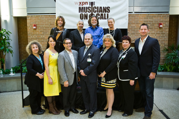 At the kickoff event for Musicians on Call at Christiana Care: (bottom row) Helen Leicht, WXPN assistant program director/Midday and Philly local host; Angela Sheik, musician; Hal Real, Light Up the Queen Foundation co-founder and board member, and World Café Live founder and CEO; Shawn R. Smith, vice president of Patient Experience; Sharon Kurfuerst, senior vice president of administration; Margarita Rodriguez-Duffy, director of Visitor & Volunteer Services; Pete Griffin, president of Musicians On Call; (top row) John Flynn, musician; Dan Tanzer, director of marketing for Delaware Supermarkets; Roger LaMay, WXPN general manager; Heather Hook, executive director of the Kenny Family Foundation.