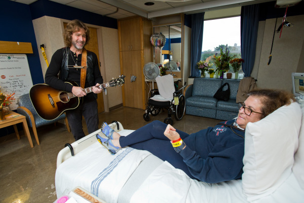 Musician John Flynn plays for Andrea Levine of North Wilmington at the Center for Rehabilitation.