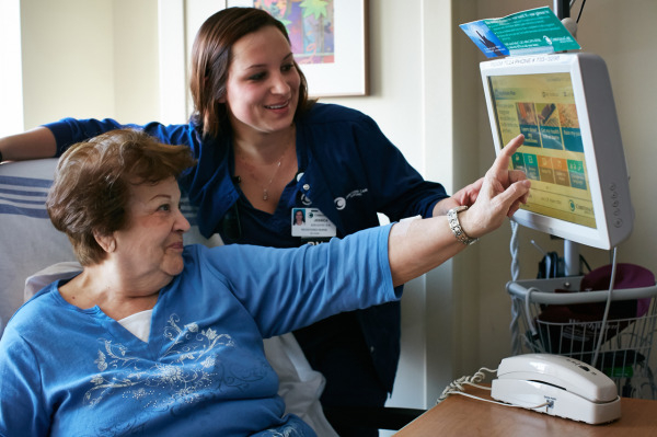 Jessica Szelestei, RN, teaches a patient how to use the GetWellNetwork, which now boasts a slick new design that puts patient education and other important information at the patient’s fingertips.