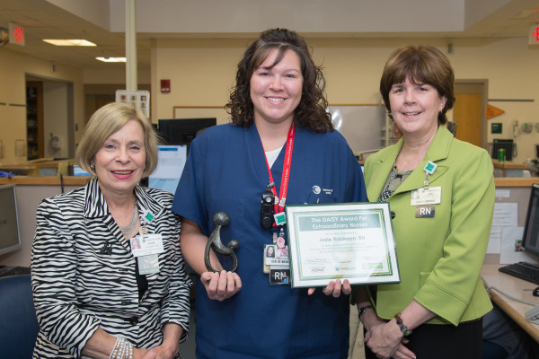 Diane Talarek, MA, RN, NE-BC, senior vice president of Patient Care Services and chief nursing officer, and Janet Cunningham, RN, MHA, NEA-BC, CENP, associate chief nursing officer and vice president of Professional Excellence, present Josie Robinson, RN, CEN, with The DAISY Award.