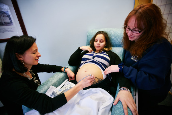 Expectant mother Malisa Azzarello and her mother listen as nurse practitioner Deanna Benner, MSN, WHNP-BC, checks the baby's heartbeat during a CenteringPregnancy session. 
