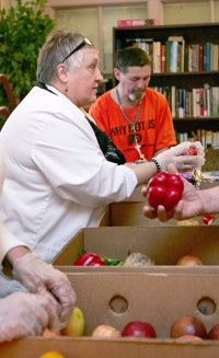 Linda Brennan Jones helps with distribution of fresh veggies and fruits.