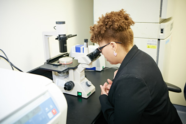 Henrietta Lacks' great-granddaughter Victoria Baptiste looks through a microscope during a tour of the Center for Translational Cancer Research at the Helen F. Graham Cancer Center & Research Institute.