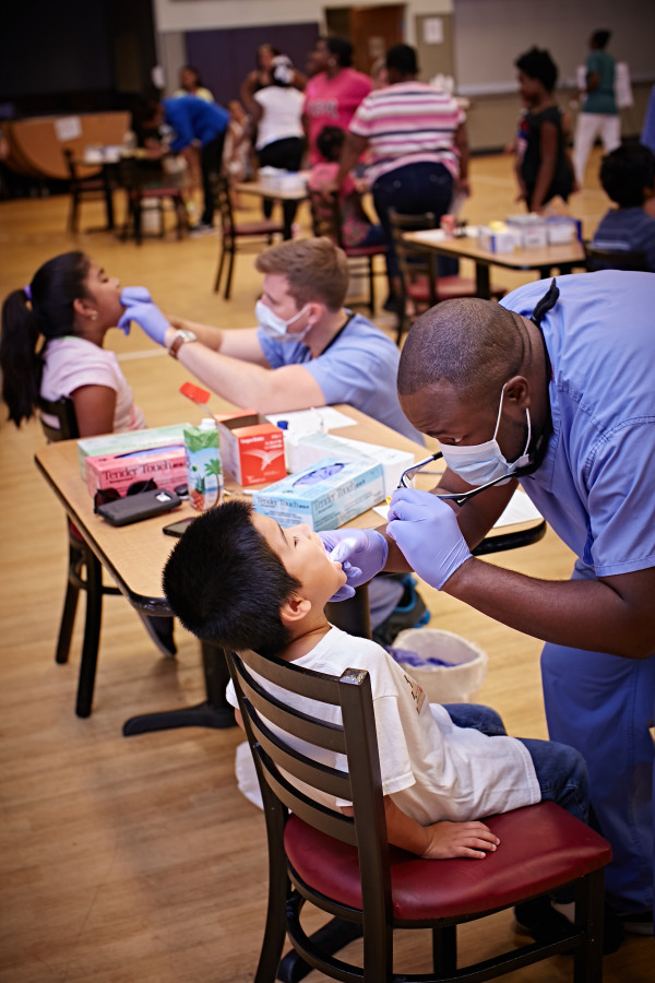 Zachary Roach, D.D.S., and Patrick Whilby, D.D.S., provide free dental screenings to kids at the Sunday Breakfast Mission’s Back-to-School Event.
