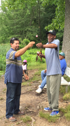 “The fish kept stealing my bait, but it was all right — it was fun!” Lonnie Stafford, right, shows off his catch to ADP staff member Angel Guevarez.