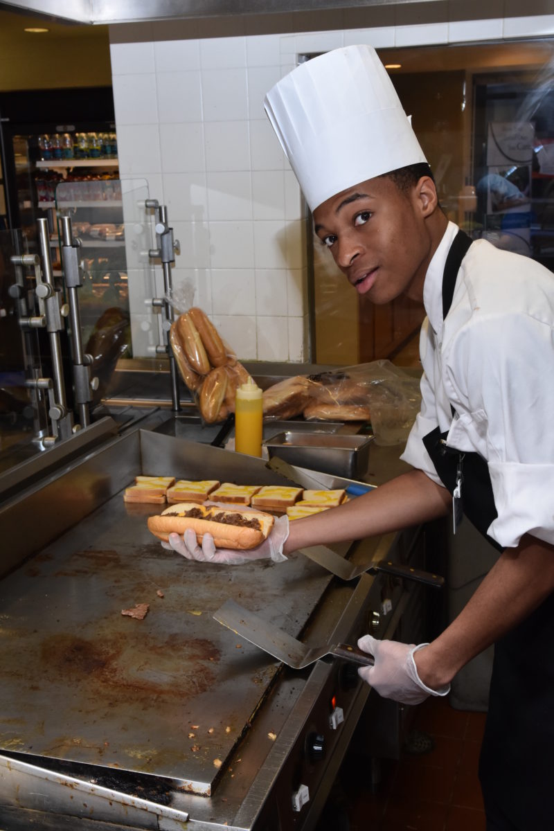 Jobs for Delaware Graduates intern Ibn Goldsborough takes a shift on the busy grill at the West End Cafe, Christiana Hospital.