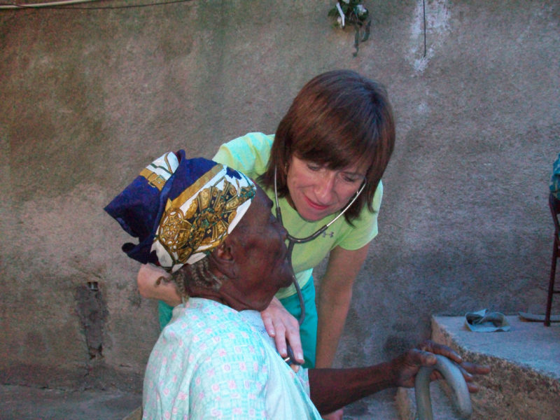 Dr. Curtin cares for a patient during one of her many medical mission trips to Haiti.
