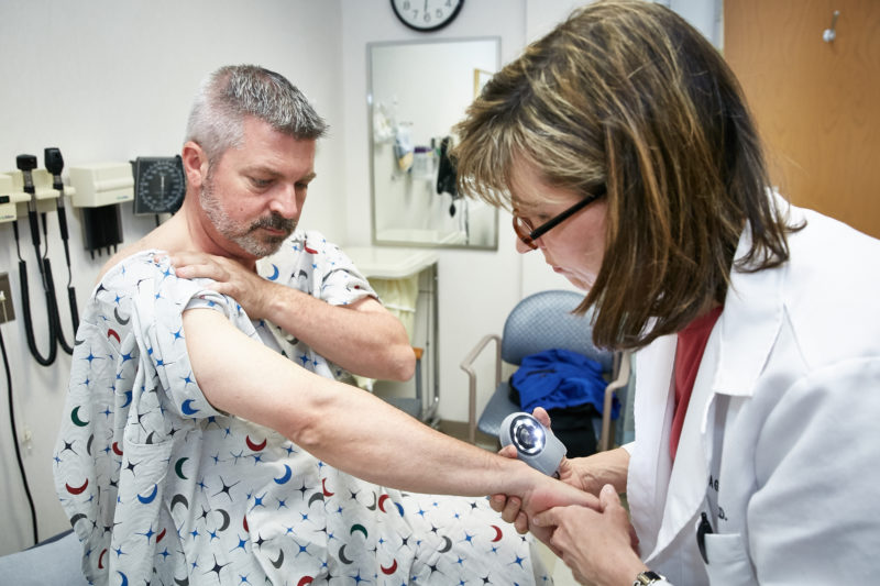 Michael Palombi, whose parents were treated for early-stage melanoma, is examined by dermatologist Cynthia Webster, M.D.. at the free skin cancer screening at the  Helen F. Graham Cancer Center & Research Institute.