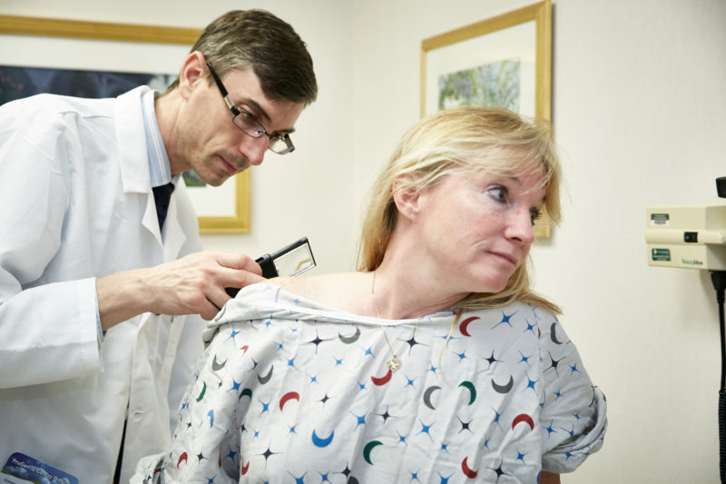 Dermatologist Matthew Hanson, M.D. examines Lisa Carr.