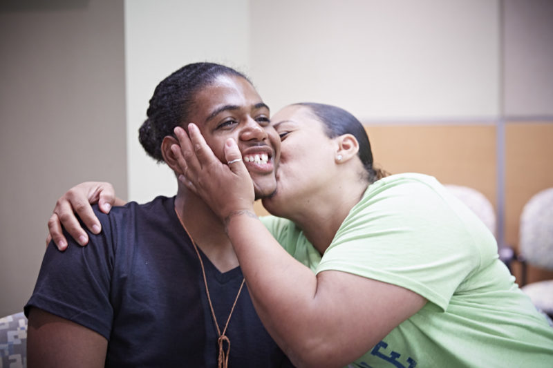 Latrell Henry gets a kiss from his mom, Bonnie Henry at the 10-year anniversary celebration of Camp FRESH.